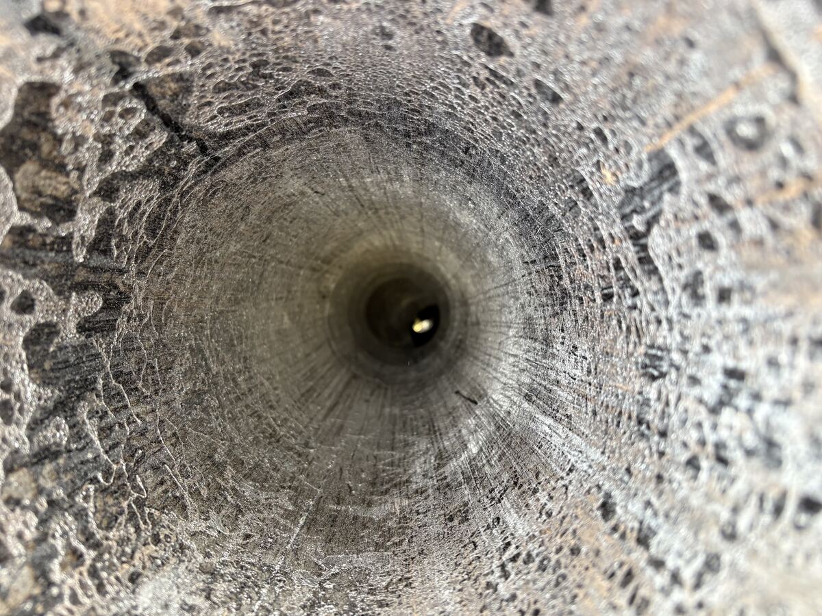 Heavy creosote buildup inside a chimney flue before cleaning